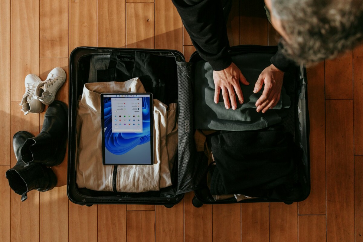 an overhead view of a person packing a suitcase